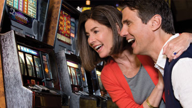 man and woman playing slot machine