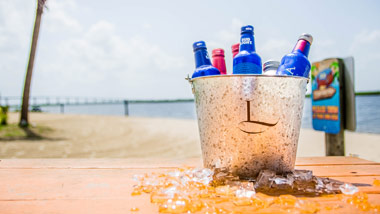 bucket of beers on a wooden table next to the bay