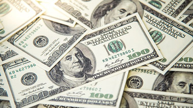 stacks of $100 dollar bills with light flare